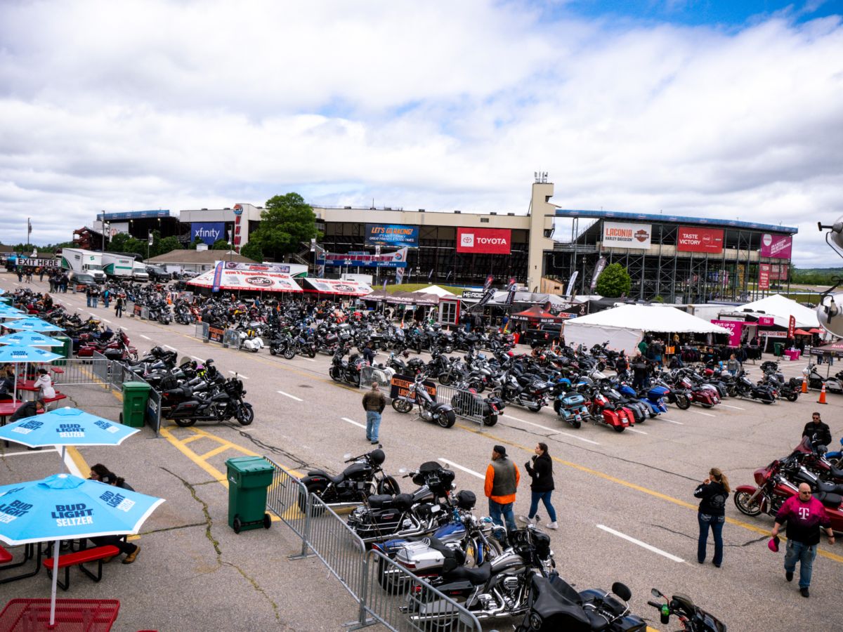 Riders testing new motorcycles at an outdoor demo area during an expo