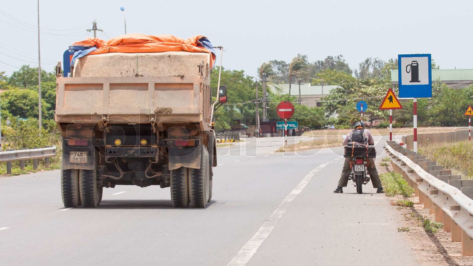A motorcycle passing a semi-truck on a busy highway