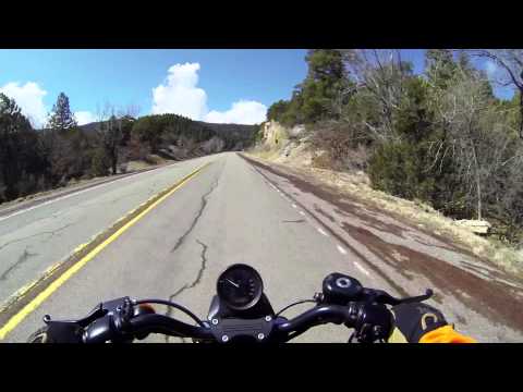 Motorcycle climbing Sandia Crest Road with dramatic elevation views