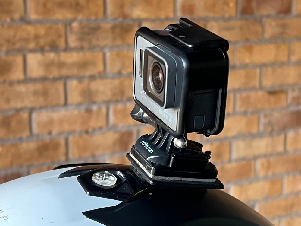 Hero image showing a rider with an action camera mounted on their helmet on an open road