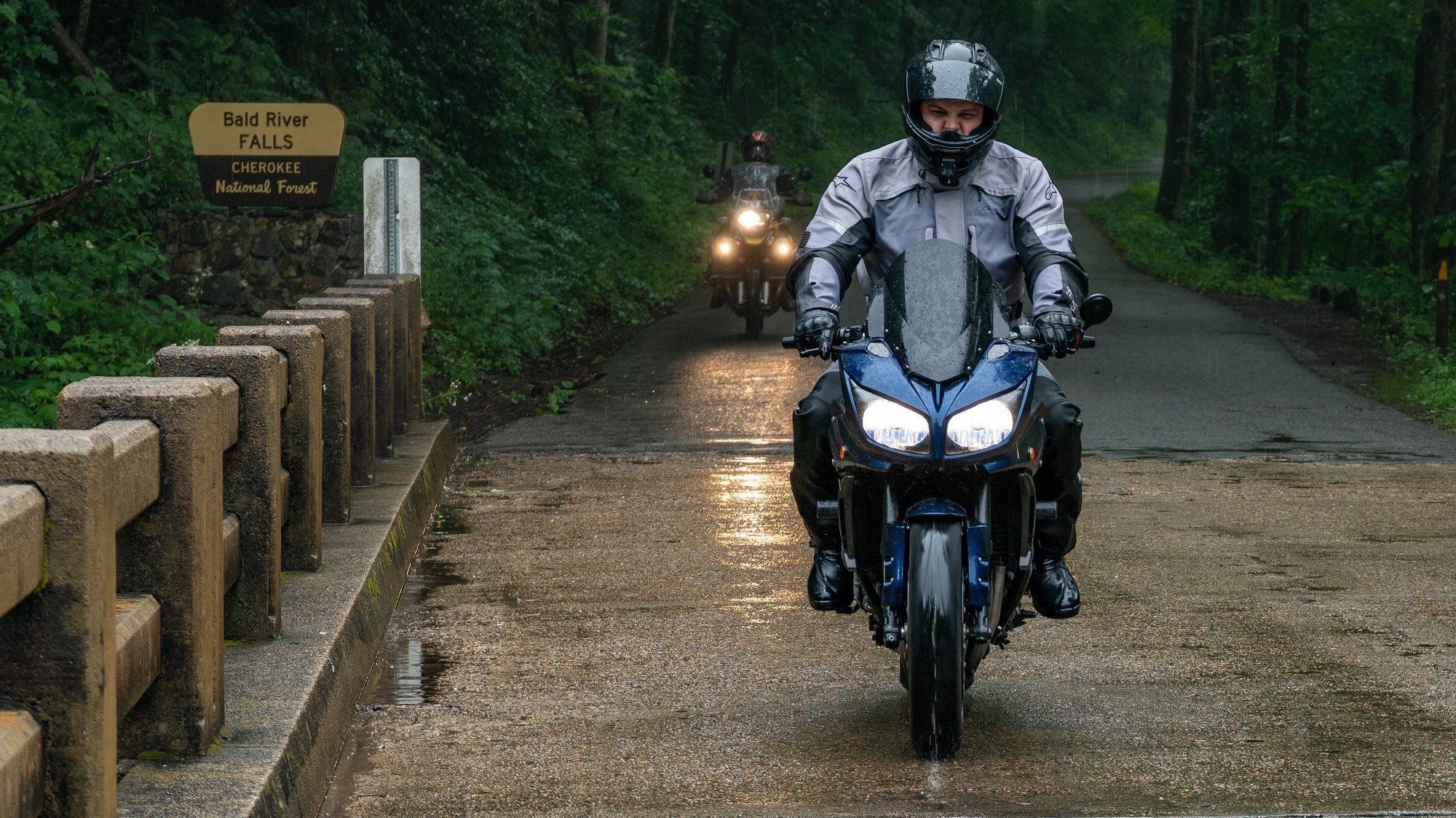 Adventure motorcycle riding in rain to illustrate weather resistance testing