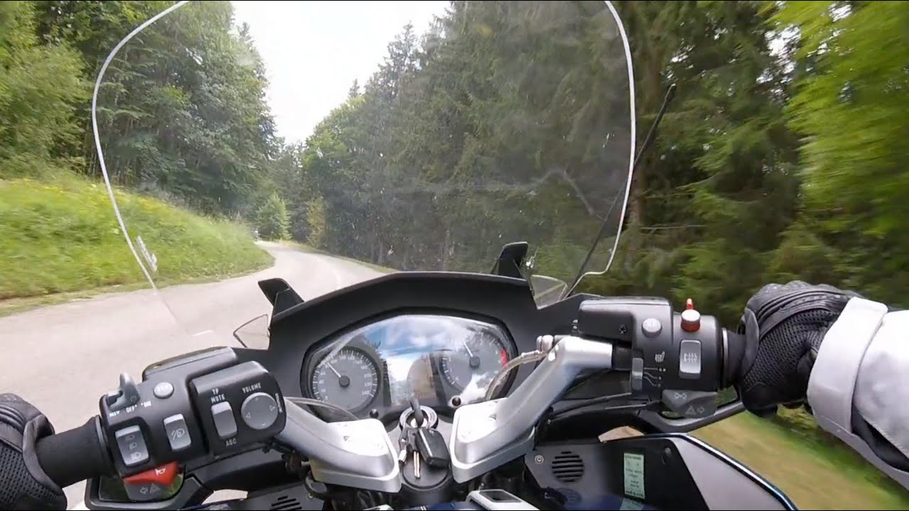 Dash cam POV or rider on twisty mountain road illustrating real-world testing