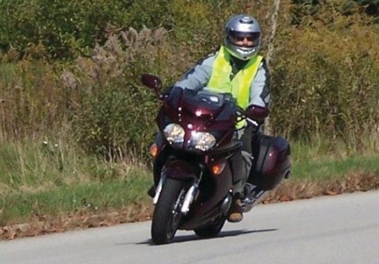 Commuter rider in low-light urban conditions wearing hi-vis overlayer