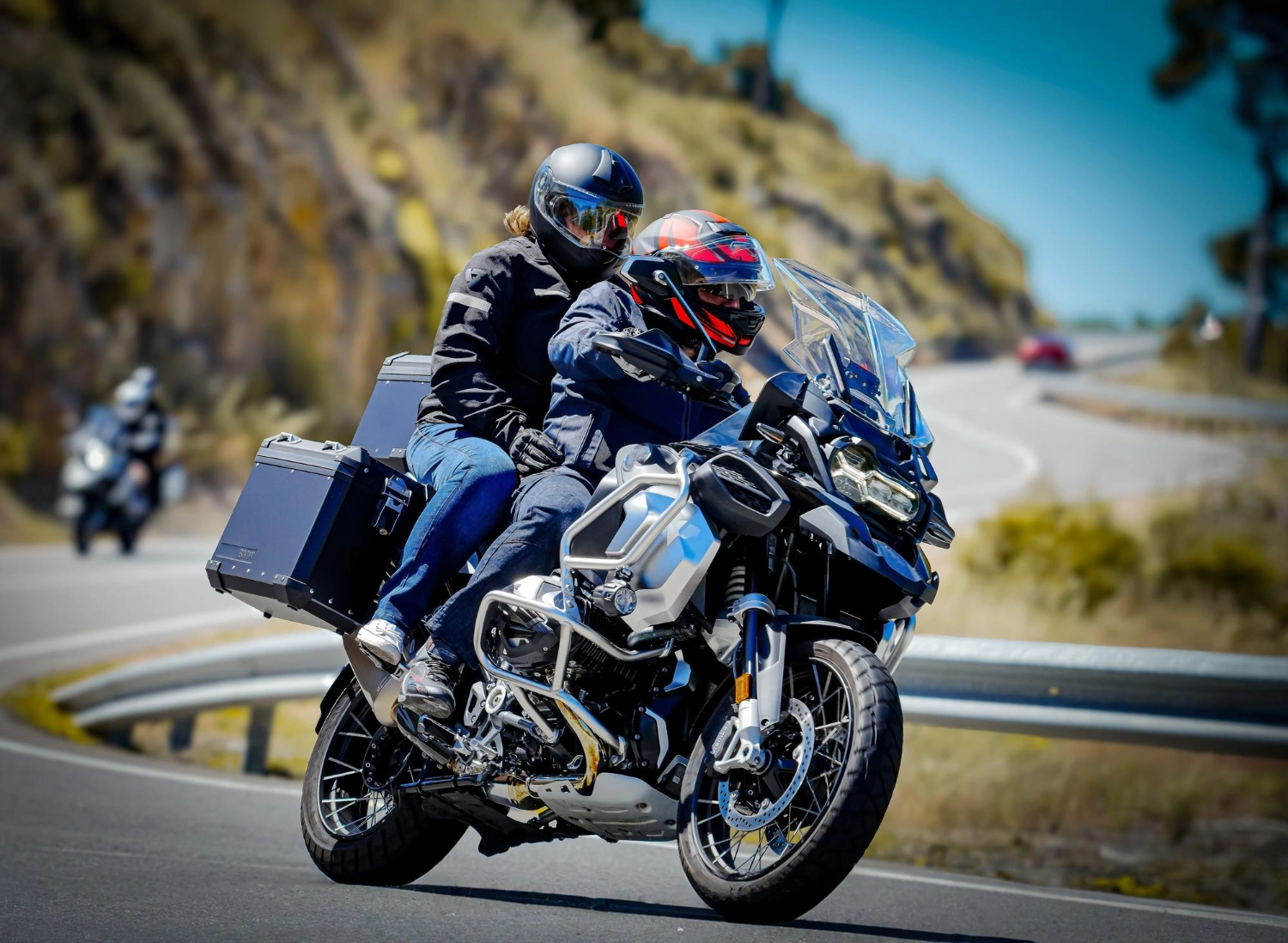 Hero image showing rider and pillion on a touring motorcycle