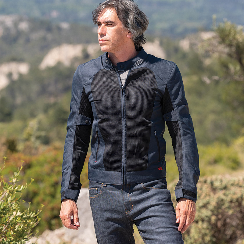 Sport rider in a leather motorcycle jacket, track or canyon setting