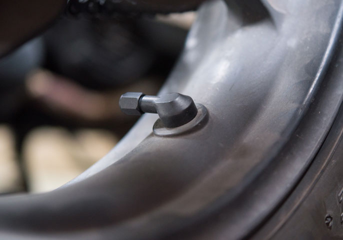 Close-up of external cap TPMS sensor on motorcycle valve stem