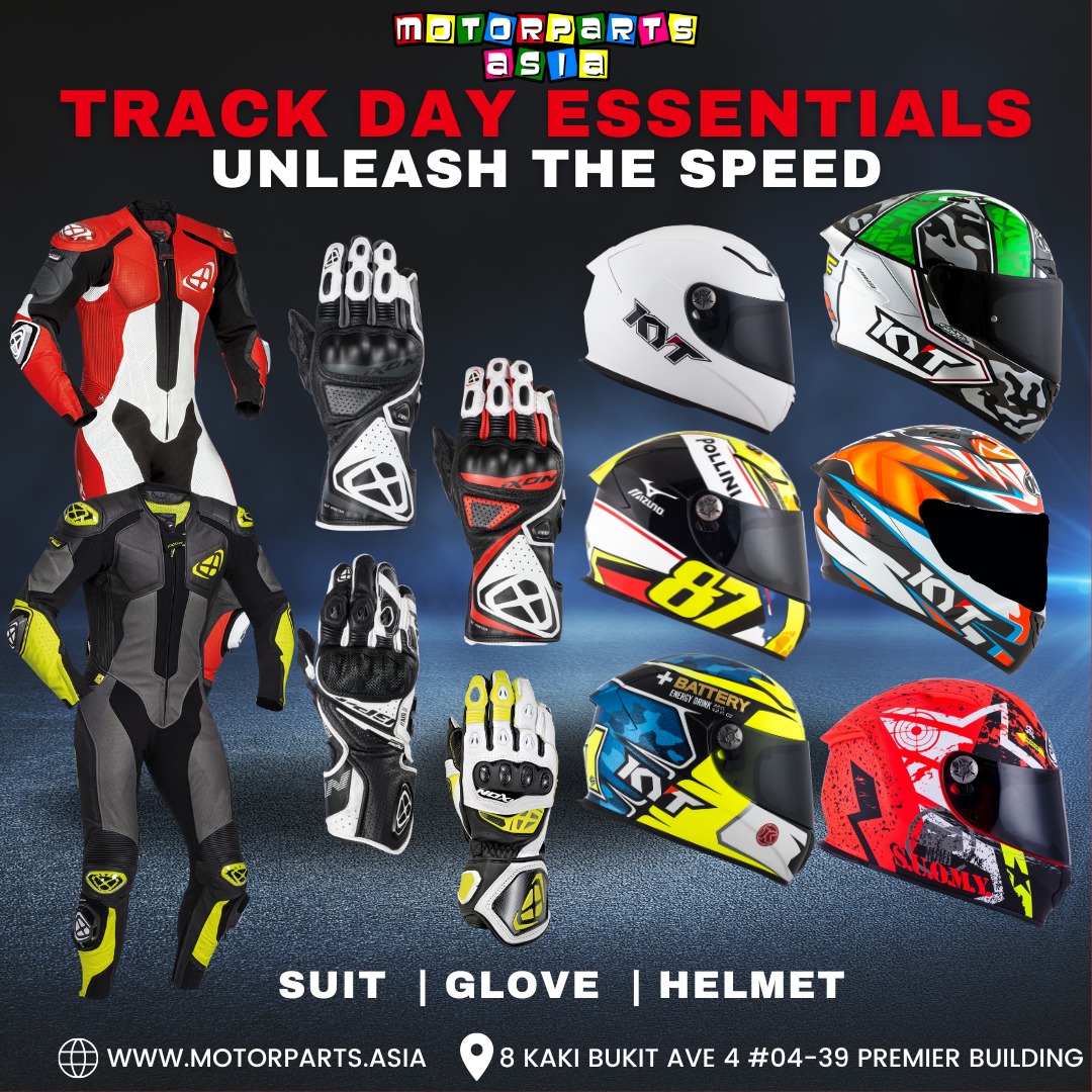 Full track day riding gear laid out or worn by a rider — leathers, helmet, gloves, boots
