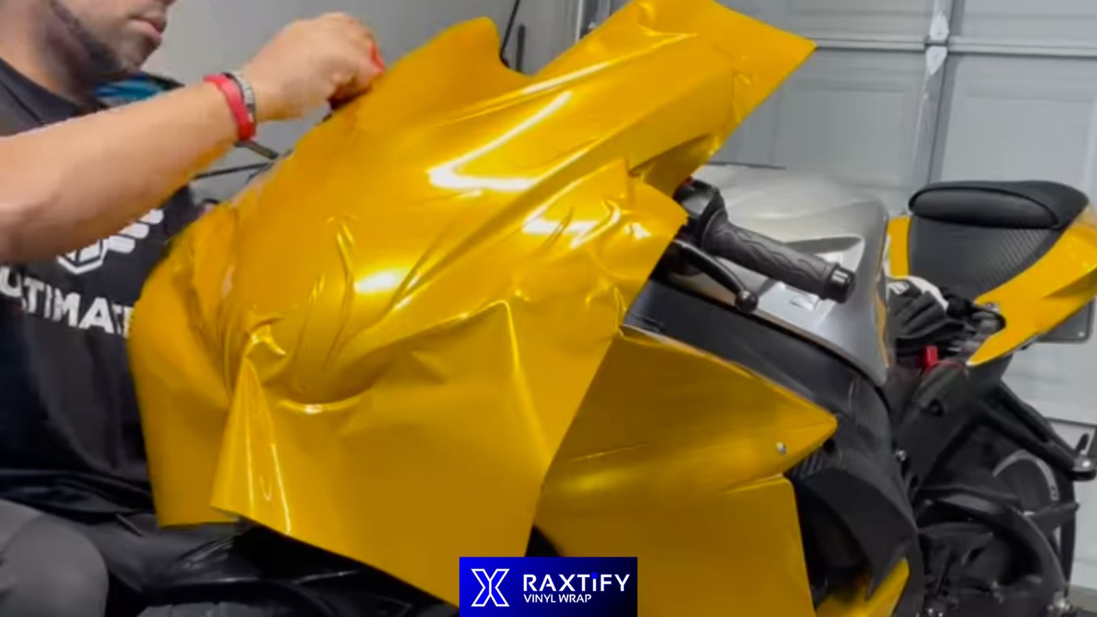 Installer applying vinyl to motorcycle fairing