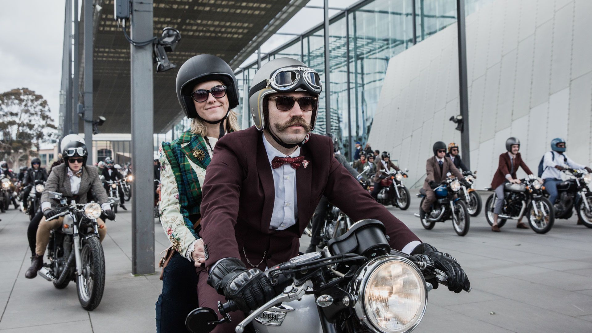 Rider in classic DGR-style dapper outfit on motorcycle