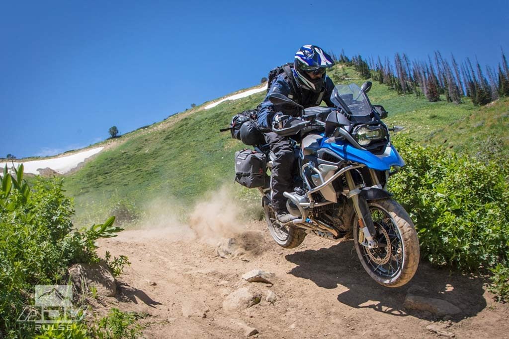 Rider on BMW GS Adventure navigating an unpaved dirt road or trail