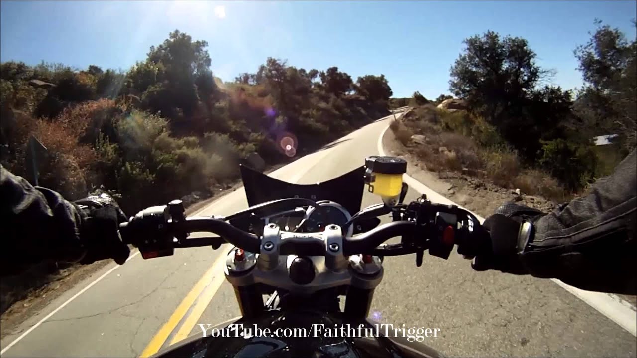 Action shot of rider on naked bike through mountain road bends