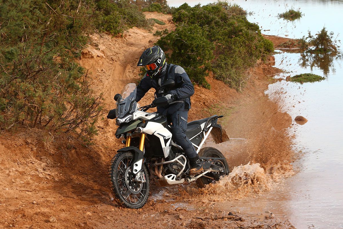 Action shot of the Tiger 900 Rally Pro on a gravel or dirt track to illustrate off-road capability section