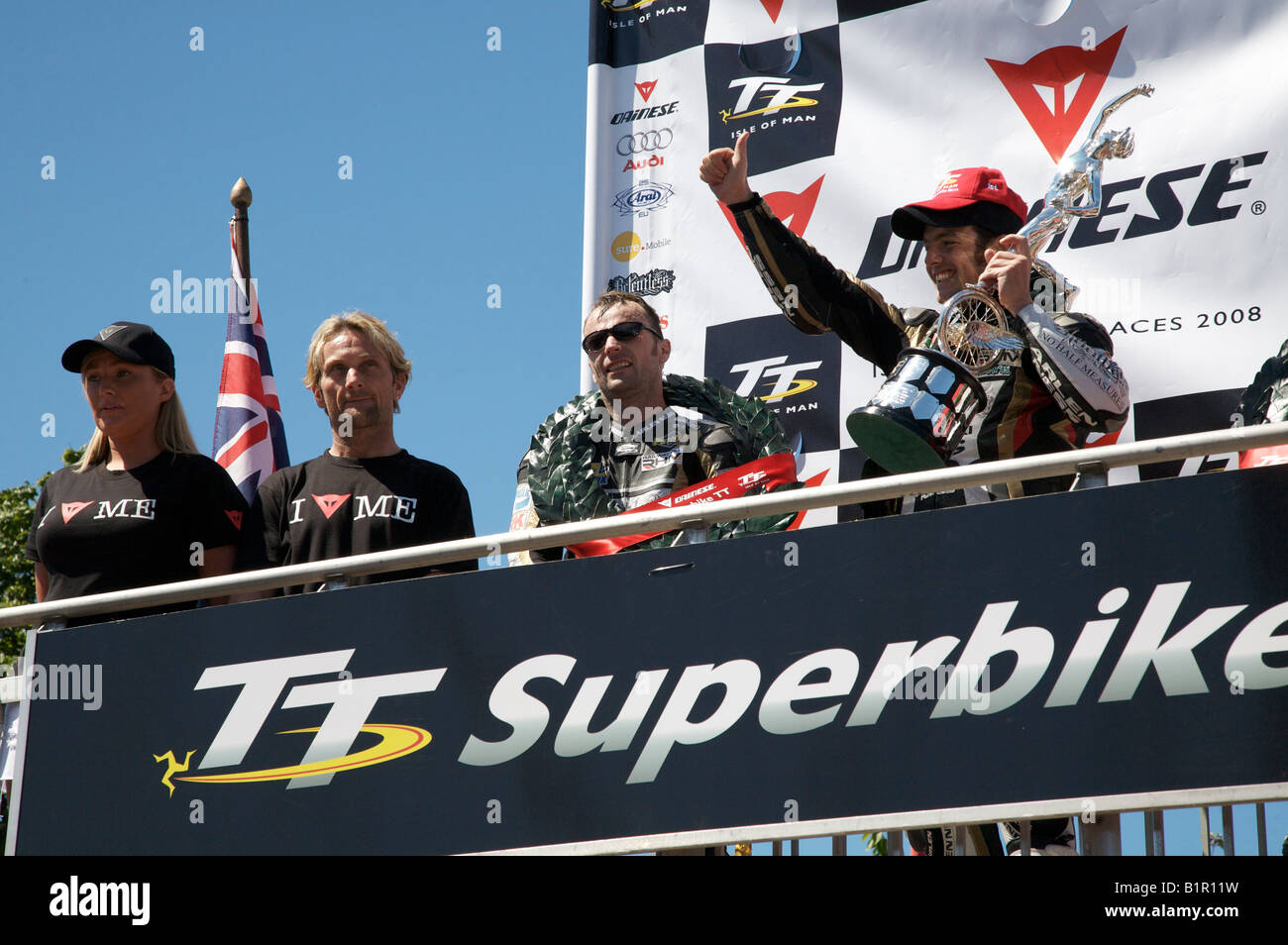 TT winner celebrating on the podium with trophy