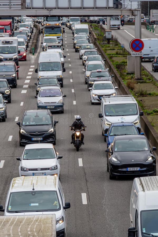 Rider splitting lanes between vehicles in heavy urban traffic
