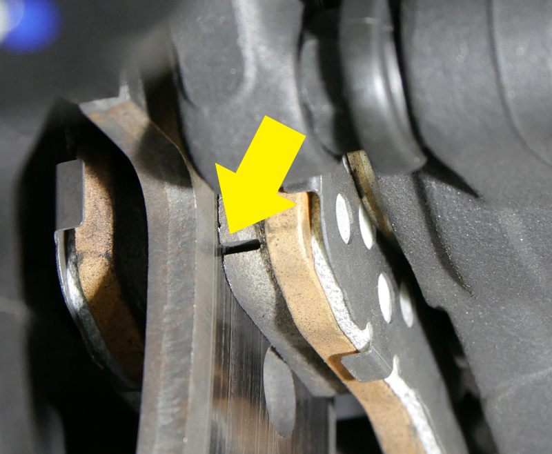 Close-up of motorcycle brake disc and caliper being inspected