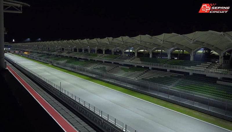 Night race atmosphere at a MotoGP circuit with floodlighting