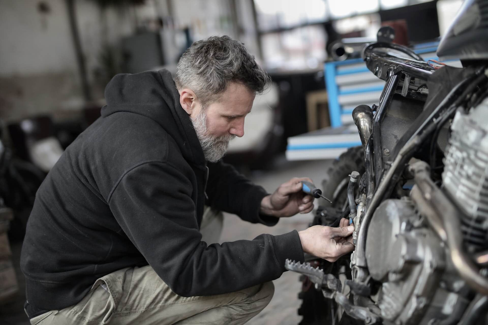 Rider or mechanic maintaining a motorcycle chain