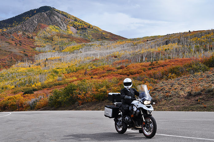 Hero image showing motorcycles riding through a Utah canyon with autumn colors